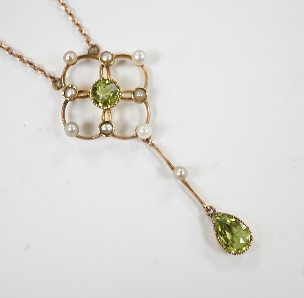 An Edwardian 9ct, peridot and seed pearl set drop pendant necklace, 49cm, gross weight 3.5 grams.